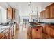 Spacious kitchen features an island with cooktop, wood cabinets, dark granite counters and hardwood floors at 1215 S Ogden St, Denver, CO 80210