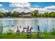 Picturesque lake view featuring geese, a charming boathouse, and a serene waterfront setting with blue skies and clouds at 1215 S Ogden St, Denver, CO 80210