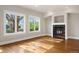 Bright living room featuring a cozy fireplace, hardwood floors, and large windows with plenty of natural light at 1215 S Ogden St, Denver, CO 80210