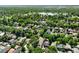 Beautiful aerial view of a green neighborhood filled with lush trees, charming houses, and a serene lake in the background at 1215 S Ogden St, Denver, CO 80210