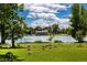 Scenic park view with a large flock of geese, a tranquil lake, and a classic boathouse in a serene natural setting at 1215 S Ogden St, Denver, CO 80210