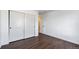 A bedroom with hardwood floors, closet with sliding doors, and a doorway that gives depth to the space at 9735 E 112Th Pl, Commerce City, CO 80640