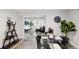 Modern dining room with a glass table, black chairs, and open floor plan to the living room at 9735 E 112Th Pl, Commerce City, CO 80640