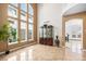 Open living room featuring soaring windows, high ceilings, tile flooring, and stylish display cabinet at 9735 E 112Th Pl, Commerce City, CO 80640