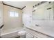 Bright bathroom featuring white tiled walls, a tub and shower combo, and a vanity with a large mirror at 1303 Havana St, Aurora, CO 80010