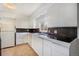 Bright kitchen with white cabinetry, tile backsplash, and stainless steel sink at 1303 Havana St, Aurora, CO 80010