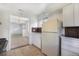 View of kitchen space into adjacent living room, featuring white cabinets and stainless appliances at 1303 Havana St, Aurora, CO 80010