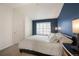 Bedroom featuring blue accent wall, neutral walls, and large window at 767 Roslyn St # 20, Denver, CO 80230