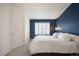 Bedroom featuring blue accent wall, neutral walls, and large window at 767 Roslyn St # 20, Denver, CO 80230