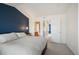 Bedroom featuring blue accent wall, neutral walls, and ensuite bathroom at 767 Roslyn St # 20, Denver, CO 80230