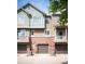 Brick townhome featuring balconies and garage doors at 767 Roslyn St # 20, Denver, CO 80230