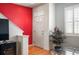 Bright foyer area with hardwood floors, a striking red accent wall, and a welcoming front door at 767 Roslyn St # 20, Denver, CO 80230