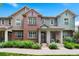 Charming townhome featuring a brick facade, well-maintained landscaping, and inviting front porch at 767 Roslyn St # 20, Denver, CO 80230
