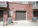 Brick condo building featuring an attached one-car garage and A/C unit at 767 Roslyn St # 20, Denver, CO 80230