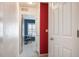 Hallway leading to office with red accent wall and view of large window at 767 Roslyn St # 20, Denver, CO 80230