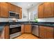 Well-equipped kitchen with stainless steel appliances and wood cabinets at 767 Roslyn St # 20, Denver, CO 80230