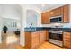 Modern kitchen with stainless appliances, wood cabinetry, and open layout at 767 Roslyn St # 20, Denver, CO 80230