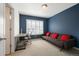 Office space with a gray futon, large window, and a desk at 767 Roslyn St # 20, Denver, CO 80230