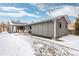 Gray home exterior showcasing backyard patio with outdoor furniture, complemented by snow-covered landscaping at 47 S Hazel Ct, Denver, CO 80219