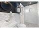 Modern bathroom with black and white tile, a large mirror, and a walk-in shower at 47 S Hazel Ct, Denver, CO 80219