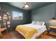 Cozy bedroom with dark green walls, hardwood floors, and natural lighting at 47 S Hazel Ct, Denver, CO 80219