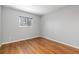 Bright bedroom with wood-look floors, a window, and neutral paint for a serene living space at 47 S Hazel Ct, Denver, CO 80219