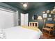 Charming bedroom with dark green walls, hardwood floors, and a comfortable chair at 47 S Hazel Ct, Denver, CO 80219