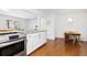 Open kitchen and breakfast nook with stainless steel appliances and hardwood flooring at 47 S Hazel Ct, Denver, CO 80219