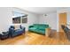 Bright living room with hardwood floors, large window, blue chair, and green sofa at 47 S Hazel Ct, Denver, CO 80219