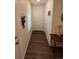 Narrow hallway with hardwood floors, neutral colored walls, a window, and access to other rooms at 47314 Iris Ave, Bennett, CO 80102