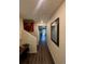 Hallway with wood flooring, neutral walls, art, and views into other rooms of the home at 47314 Iris Ave, Bennett, CO 80102