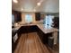 Well-lit kitchen with dark wood cabinets, granite countertops, stainless steel sink and wood floors at 47314 Iris Ave, Bennett, CO 80102