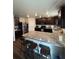 Updated kitchen with granite countertops, dark wood cabinets, stainless steel appliances, and a breakfast bar at 47314 Iris Ave, Bennett, CO 80102
