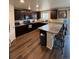 Modern kitchen with dark cabinetry, granite countertops, stainless appliances and barstool seating at 47314 Iris Ave, Bennett, CO 80102