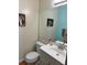 Cozy half bathroom featuring a single sink vanity and a framed mirror at 1778 S Lee St, Lakewood, CO 80232