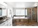 Bathroom featuring tile floors, a large tub, and glass enclosed shower at 5951 E Irish Pl, Centennial, CO 80112