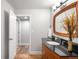 Bathroom featuring stylish vanity with dark countertop and wood-framed mirror at 5951 E Irish Pl, Centennial, CO 80112