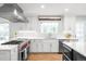 Modern kitchen with white cabinets, stainless steel appliances, and ample counter space at 5951 E Irish Pl, Centennial, CO 80112