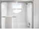 Bright, tiled shower with a glass door, white tiles, and a chrome shower head at 5951 E Irish Pl, Centennial, CO 80112