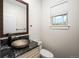 Stylish powder room featuring a vessel sink and decorative vanity with a large window at 5372 W 68Th Ave, Arvada, CO 80003