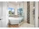 Bright bathroom with a soaking tub, a glass-enclosed shower, and natural light from two windows at 5372 W 68Th Ave, Arvada, CO 80003
