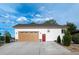 Side view of a white house showcasing a large garage, a red door, and manicured landscaping at 5372 W 68Th Ave, Arvada, CO 80003