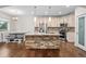 Modern kitchen featuring a center island with stone accents, stainless steel appliances, and dark hardwood floors at 5372 W 68Th Ave, Arvada, CO 80003