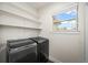 Modern laundry room featuring a window, shelving, and sleek, side-by-side washer and dryer at 5372 W 68Th Ave, Arvada, CO 80003