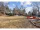 Expansive backyard with a wooden deck, bordered by mature trees and a wood fence for privacy at 8836 E Phillips Pl, Centennial, CO 80112