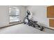 Neutral bedroom space with workout machine and natural light from the window at 8836 E Phillips Pl, Centennial, CO 80112