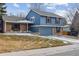 Charming home with a brick and blue siding facade, a well-manicured lawn, and an attached garage at 8836 E Phillips Pl, Centennial, CO 80112