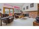 Cozy living room featuring a brick fireplace and large windows for ample natural light at 8836 E Phillips Pl, Centennial, CO 80112