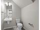 Compact bathroom with a modern toilet, wall-mounted sink, and neutral wall color at 9468 W 58Th Ln # C, Arvada, CO 80002