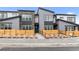 Modern townhouse featuring gray siding, stone accents, large windows, and inviting landscaping at 9468 W 58Th Ln # C, Arvada, CO 80002